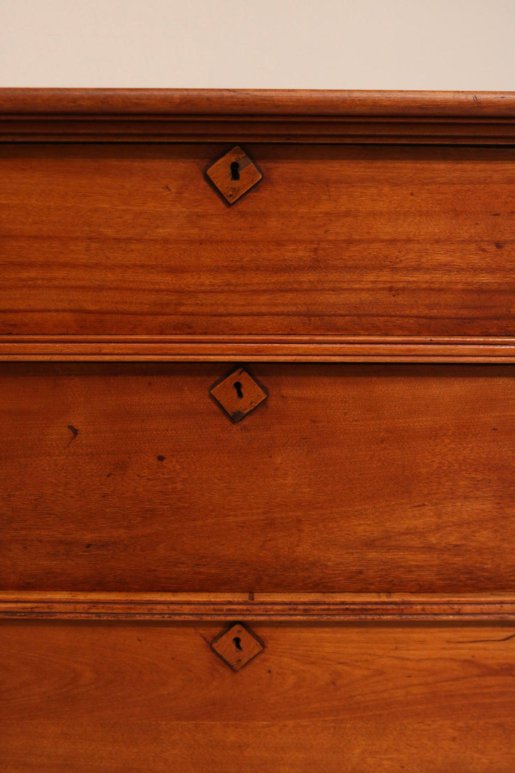 Macro detail of antique keyhole lock embedded in cherry pine wood
