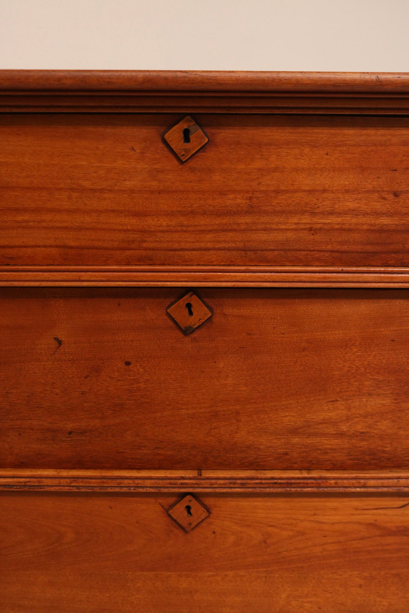 Macro detail of antique keyhole lock embedded in cherry pine wood