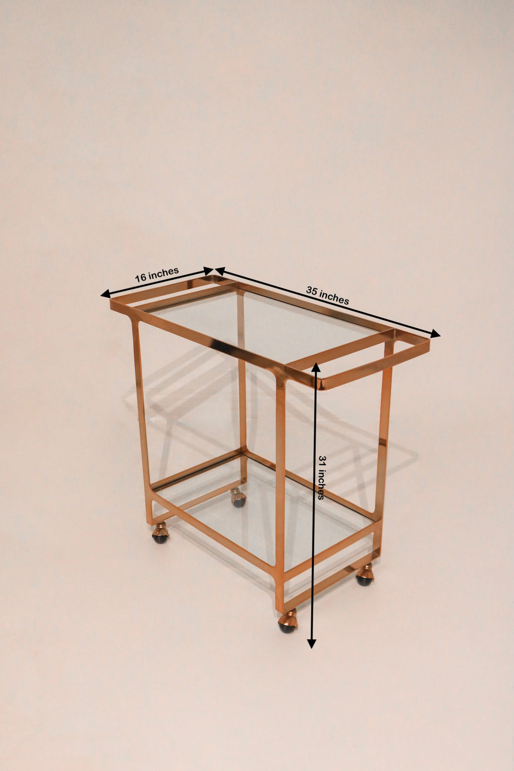 Top-down angled view of bar cart showing glass shelves and rose gold frame
