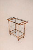 Top-down angled view of bar cart showing glass shelves and rose gold frame