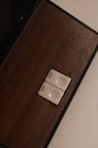 Close-up of the base featuring dual push-button switches and wood insert