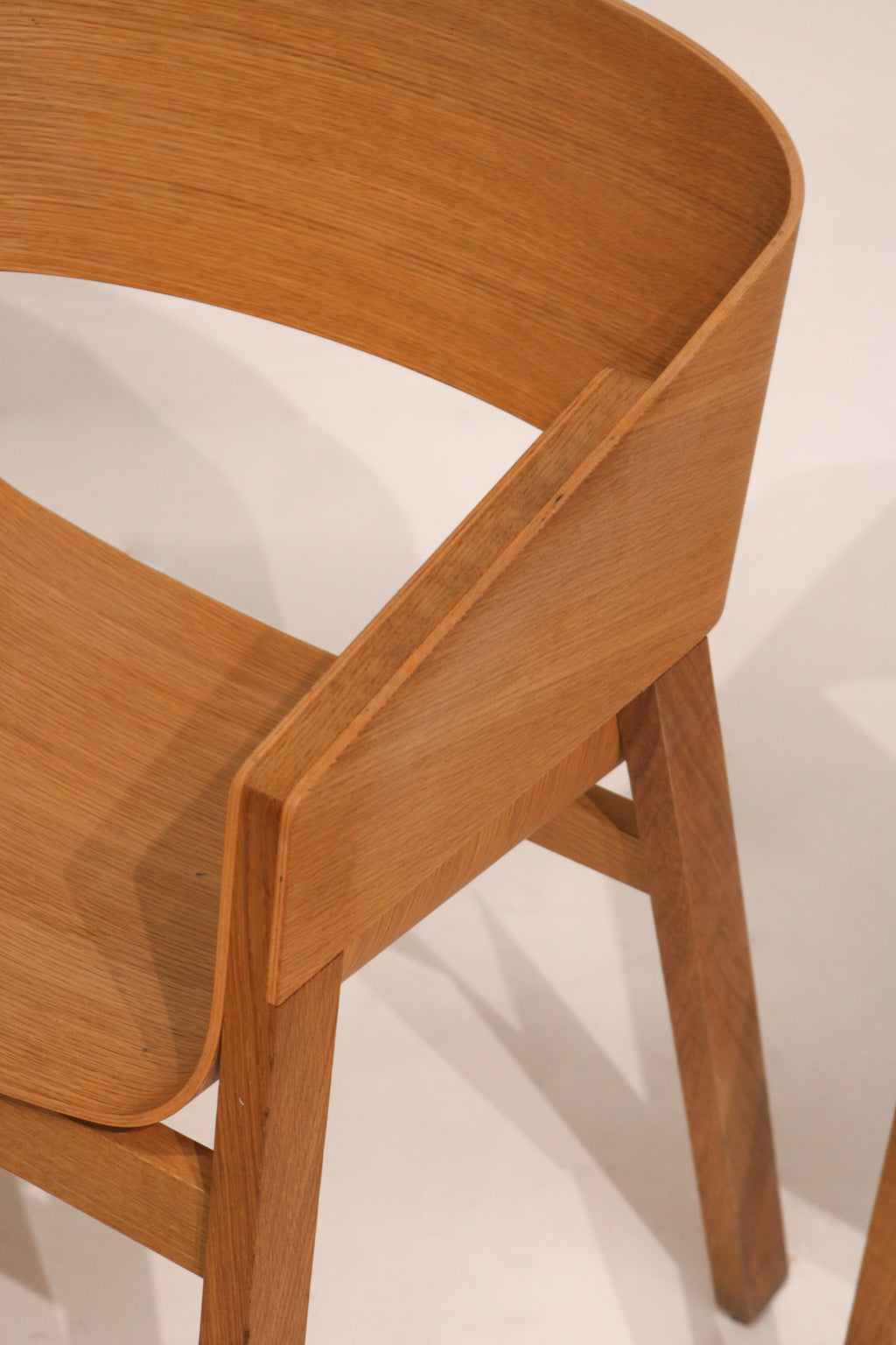 Front-side view showing curved plywood backrest and ergonomic seat form