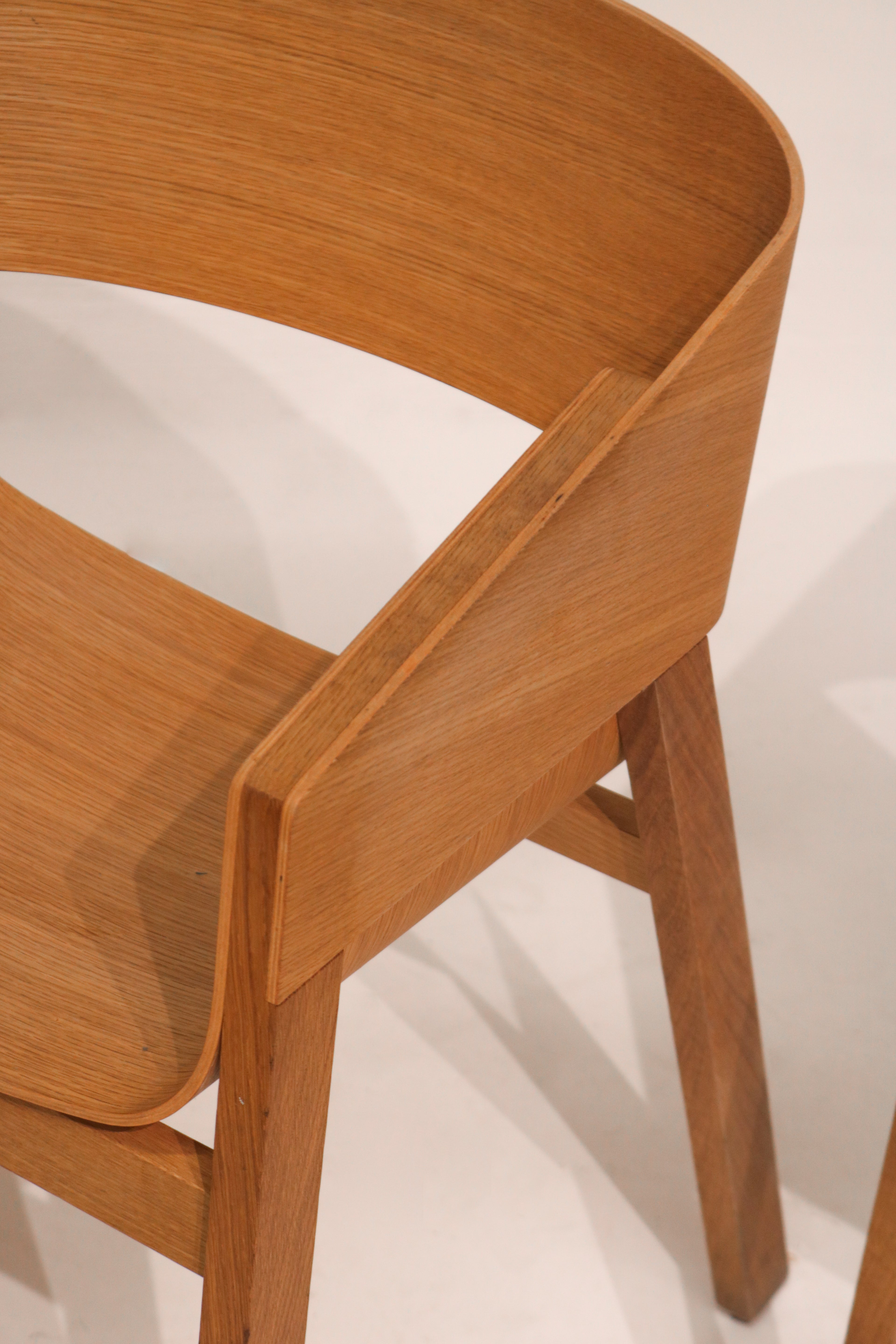 Front-side view showing curved plywood backrest and ergonomic seat form