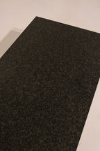 Top view close-up of black stone surface texture and speckled pattern