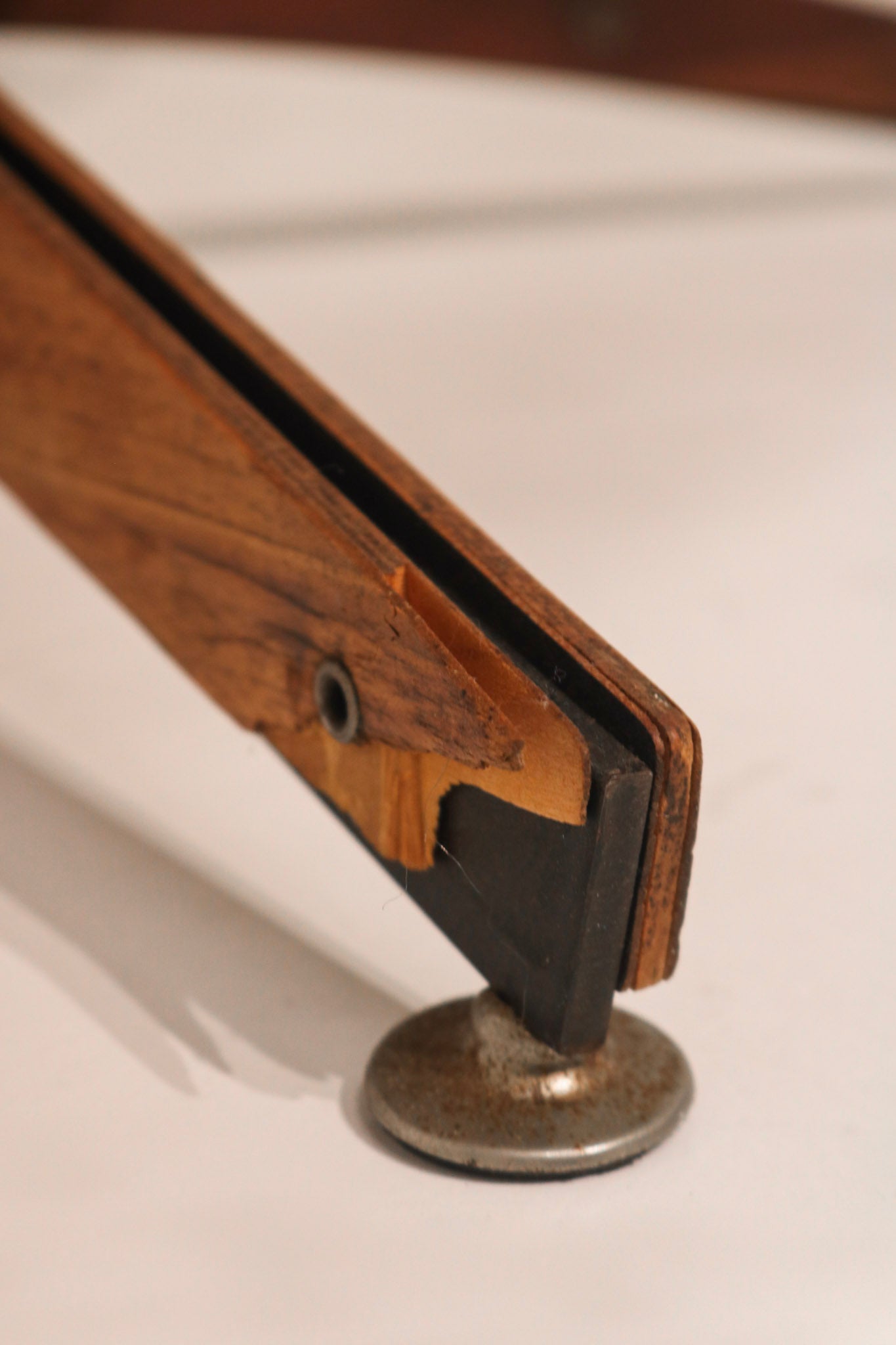 Close-up of black leather button tufting on the high backrest