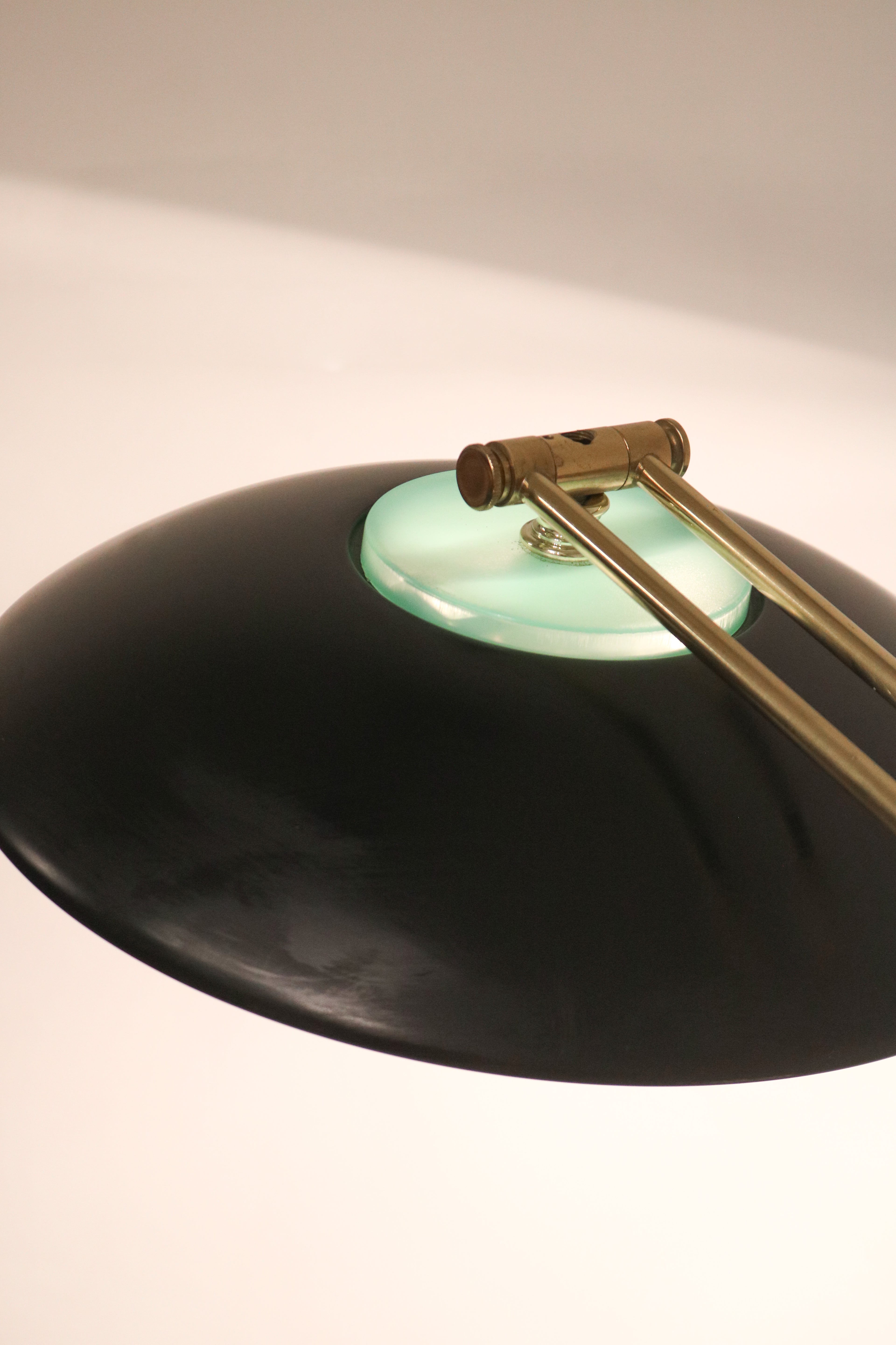 Top view of the black metal shade and brass arm connection