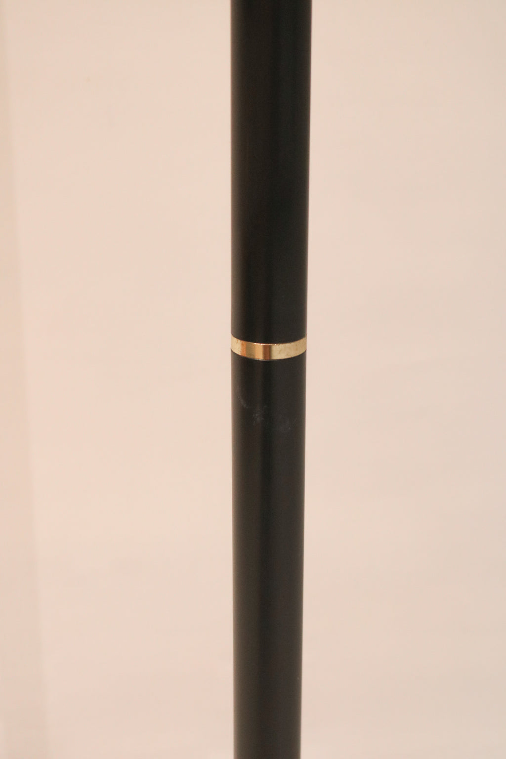 Detail of the black metal pole with decorative brass accent ring