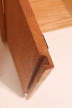 Open cabinet door detail showing hinge mechanism and solid wood thickness