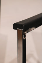 Chrome armrest detail highlighting black fabric upholstery on steel frame