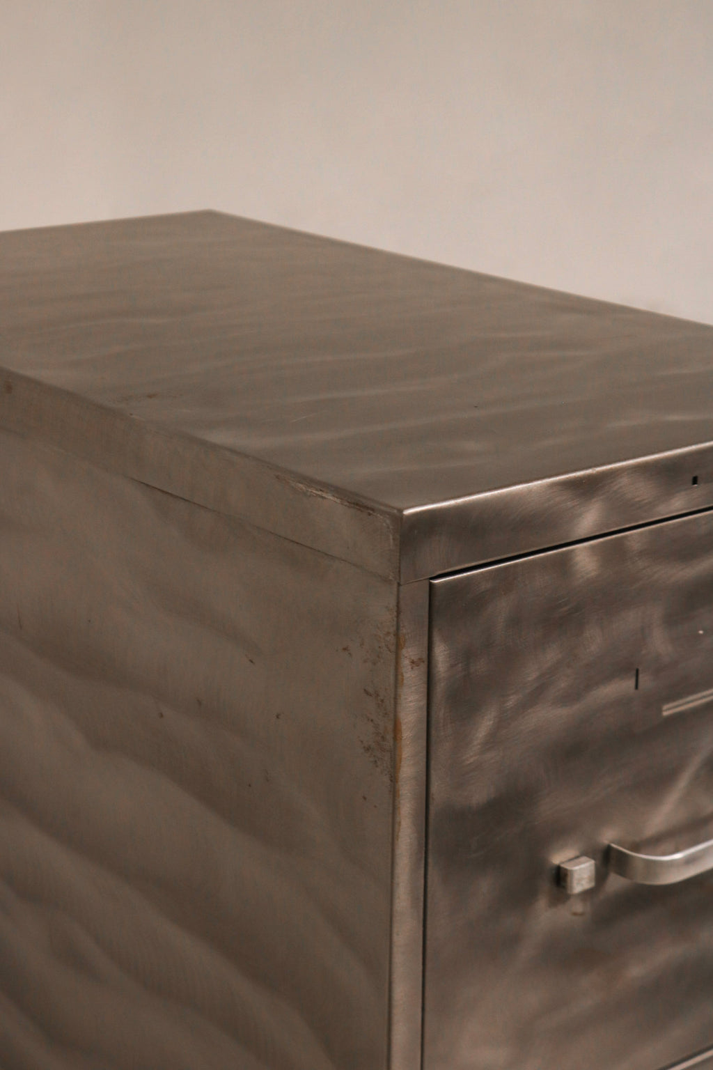 Close-up of closed metal drawer fronts showing brushed finish texture