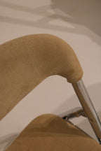 Detail of curved upholstered backrest attached to chrome tubular frame
