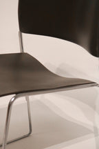 Side detail view of curved black seat and chrome frame connection