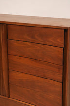 Close-up of the curved drawer fronts showing matched walnut grain