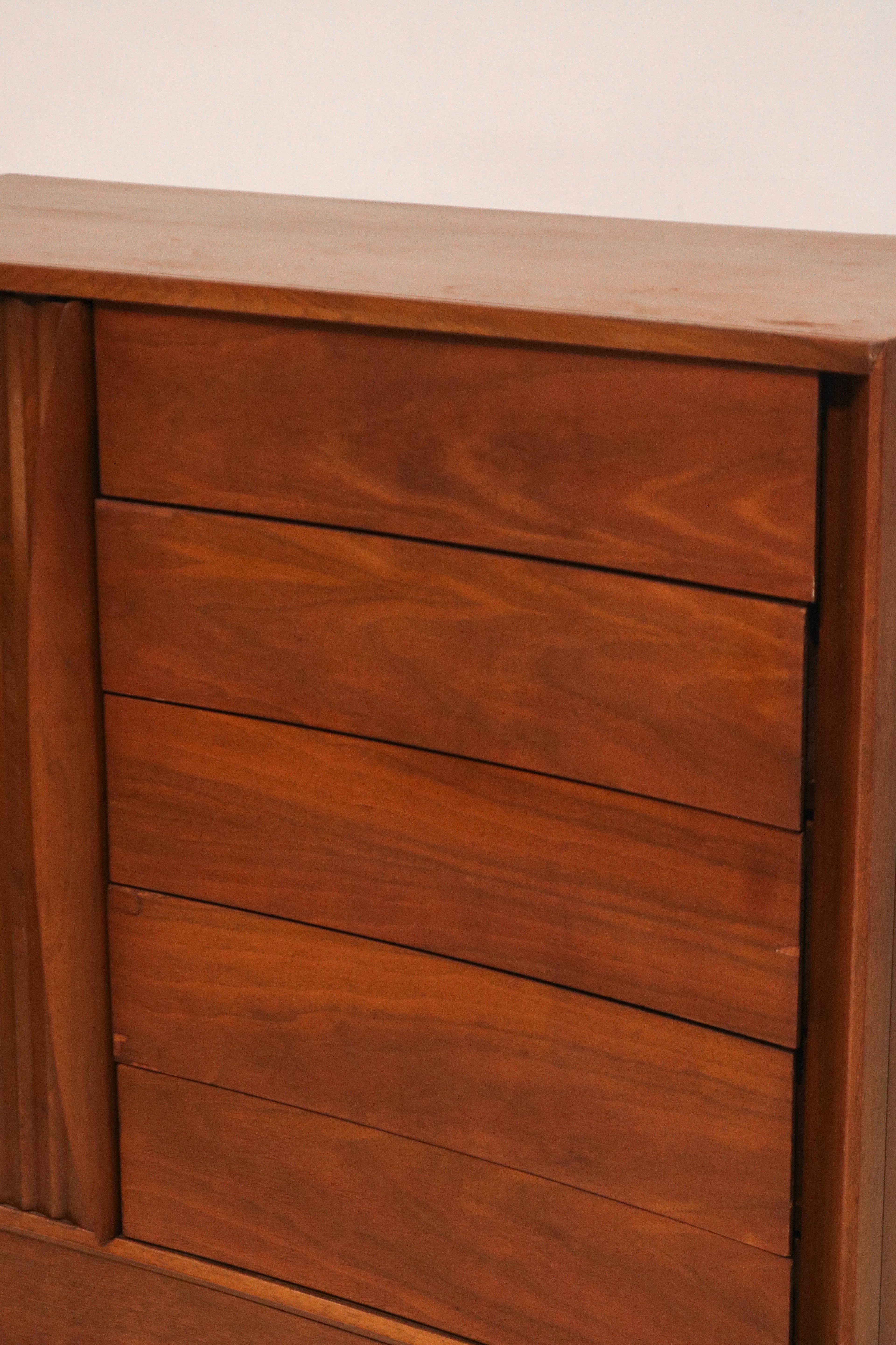 Close-up of the curved drawer fronts showing matched walnut grain