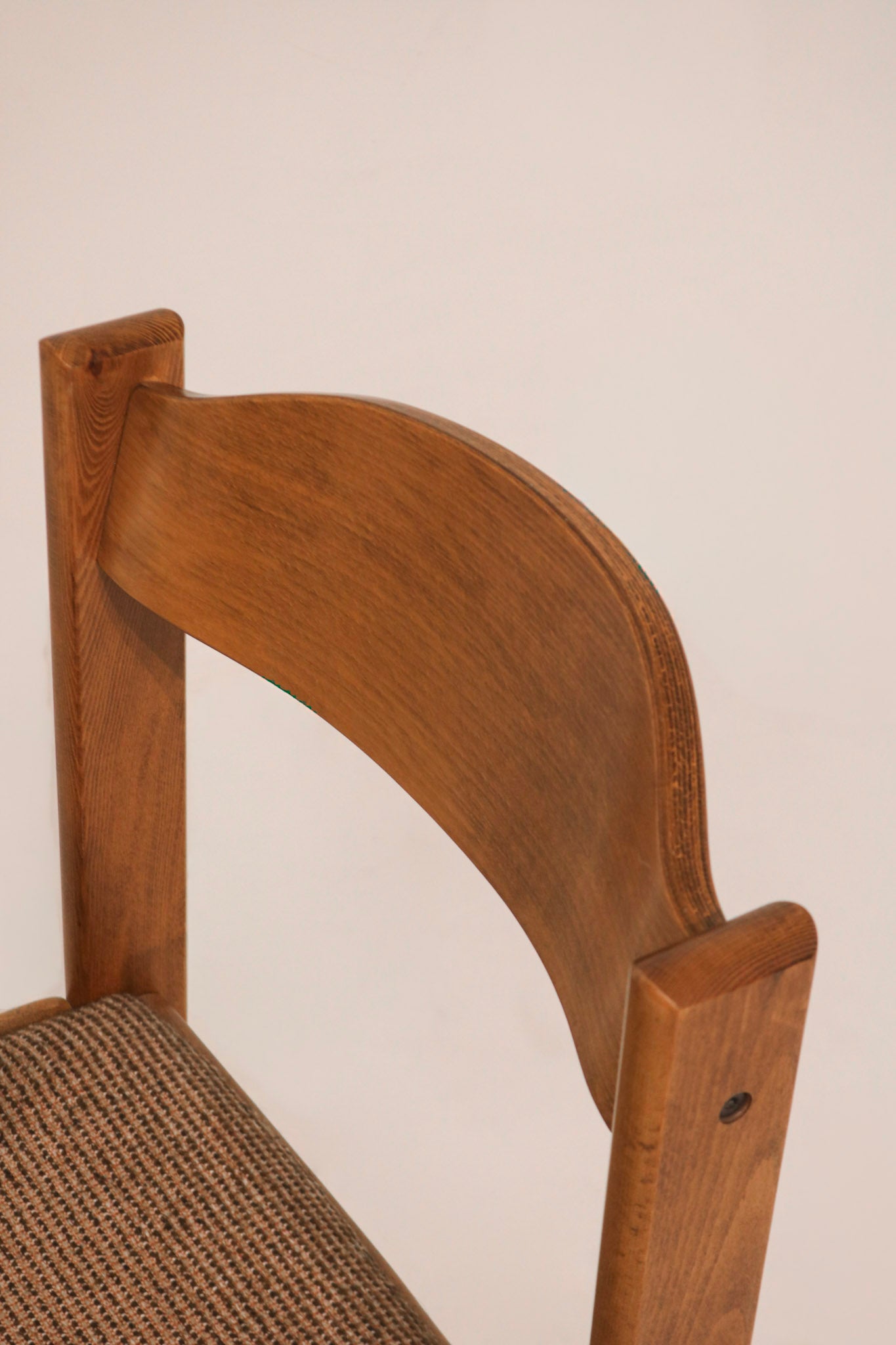 Detail of curved solid oak backrest showing wood grain and finish