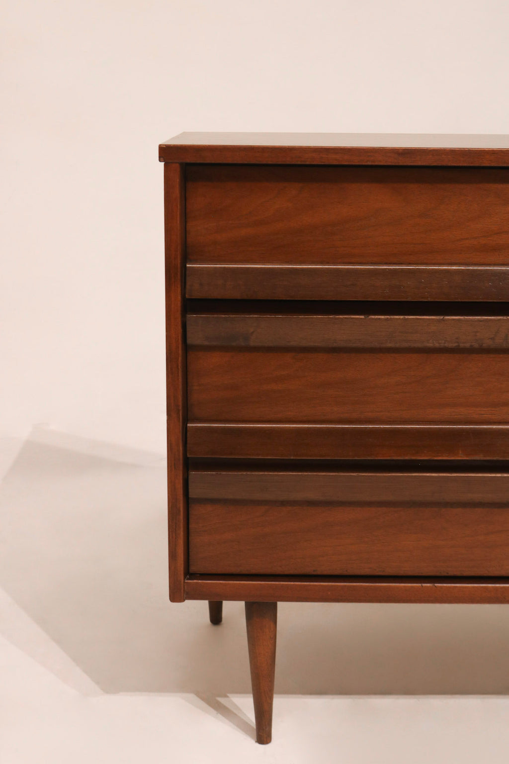 Close-up of drawer handles made of carved wood on Mcm Lowboy Dresser by Bassett