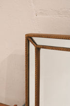 Detail of mirror edge and gold wood frame transition, featuring clean joinery and elegant lines