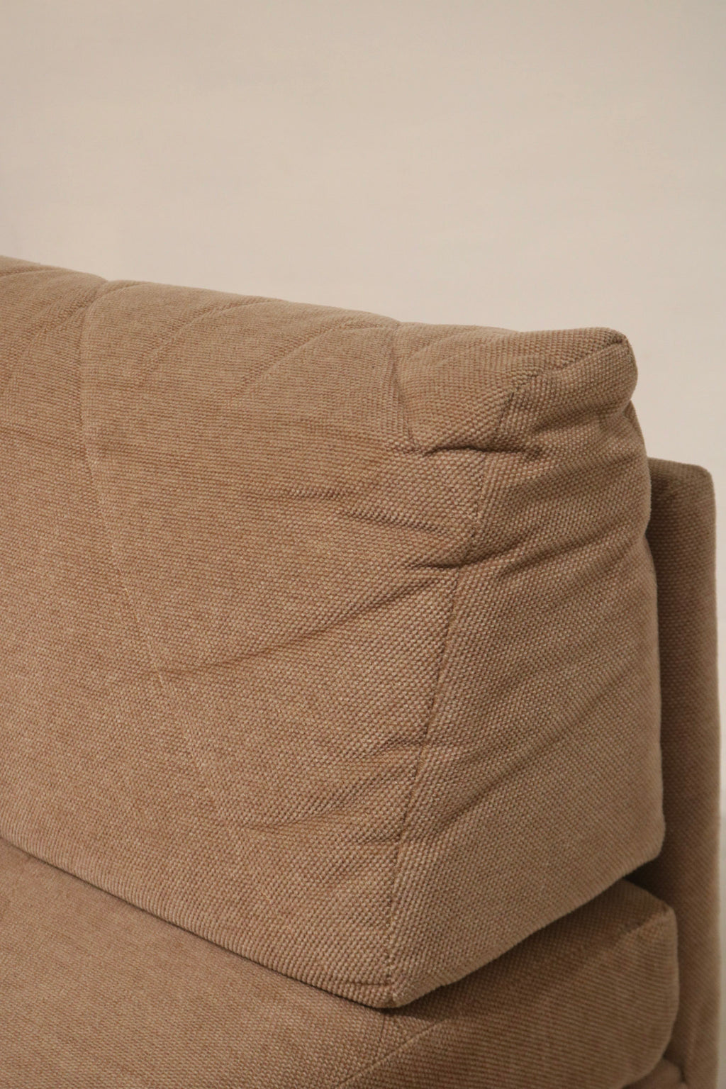 Under-seat view of Mcm modular fabric sofa showing cushion base, fabric lining and support structure indicative of durable MCM build