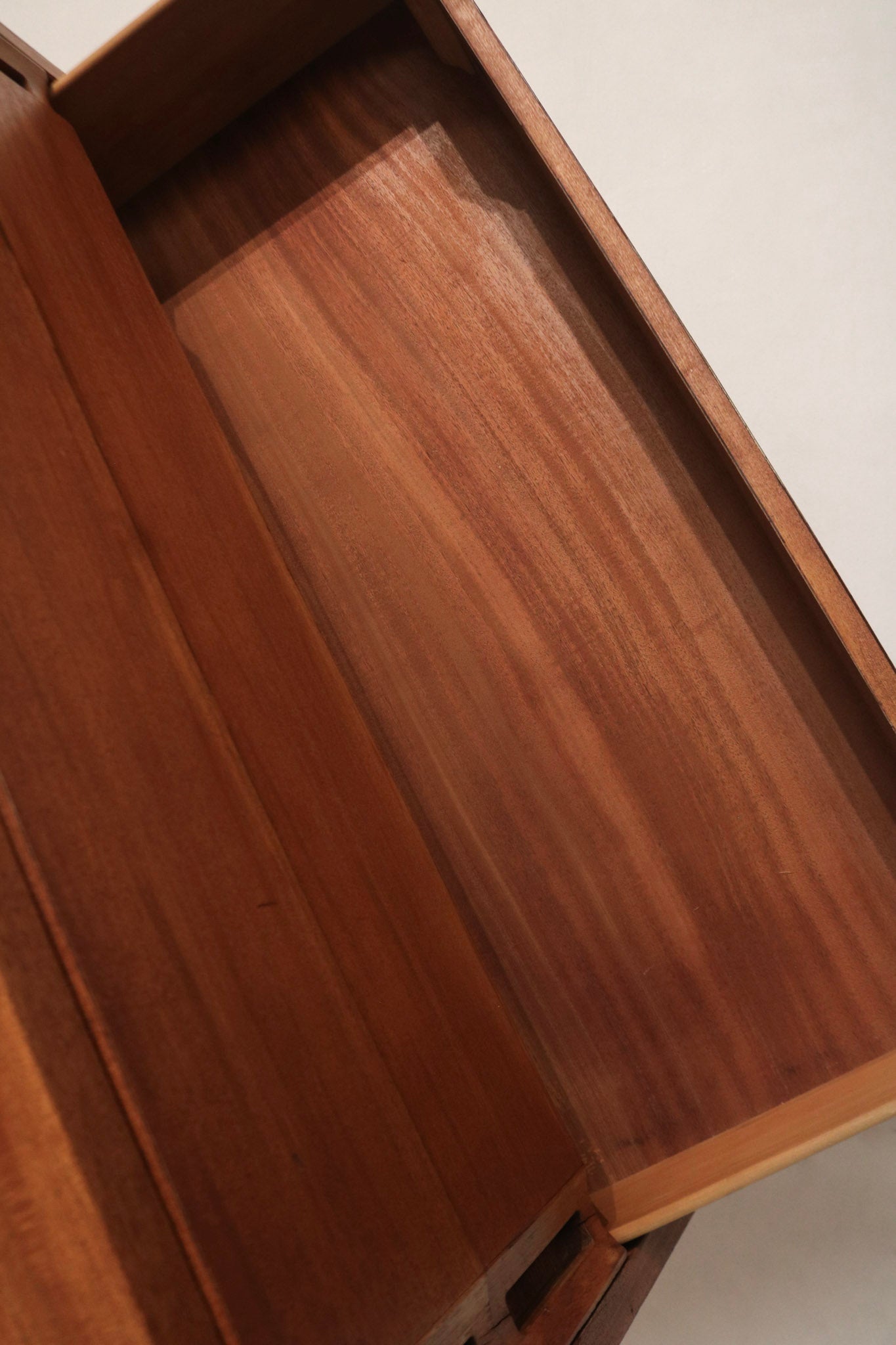 Texture detail of sanded and stained wood surface on dresser chest, close grain patterns and warm walnut tone on solid wood