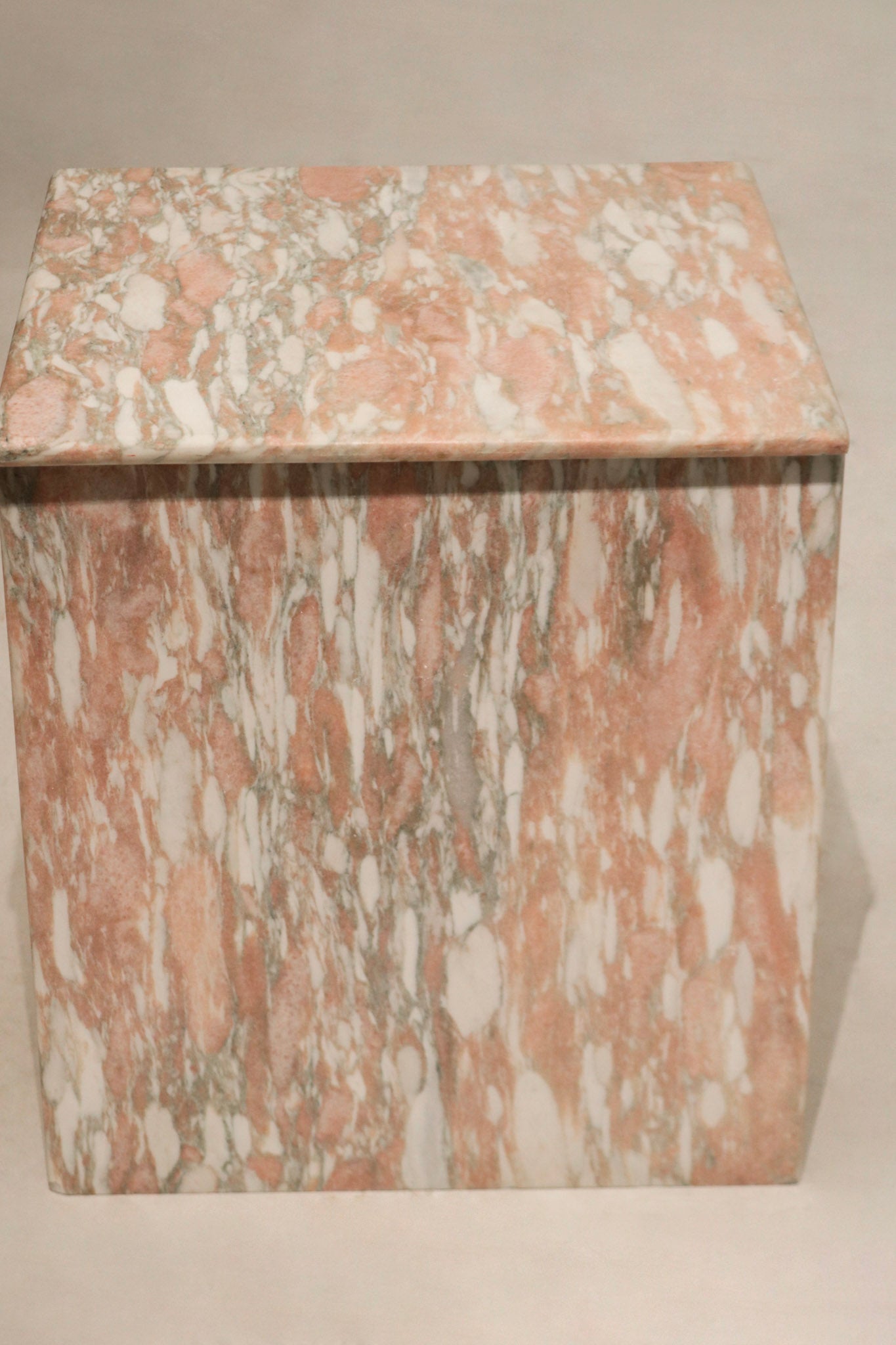 Close-up detail of natural pink marble texture with white veins, polished finish and solid marble construction visible.