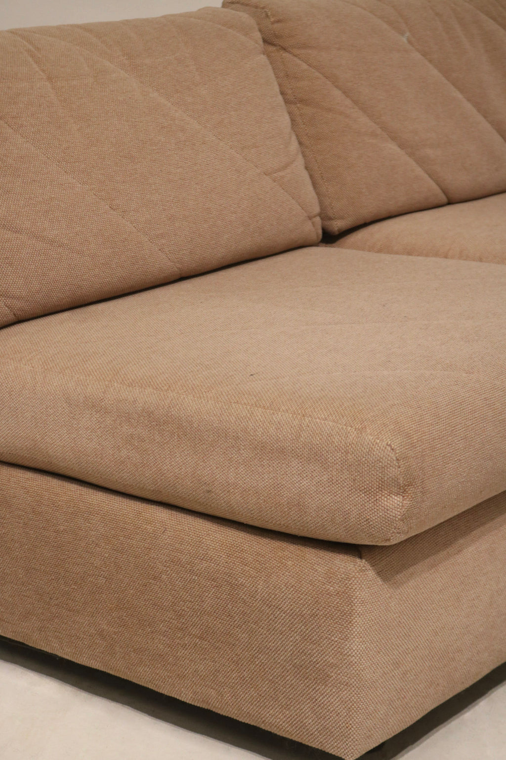 Close shot of small white paint stain on fabric of Mcm modular sectional sofa highlighting blemish location and overall clean condition