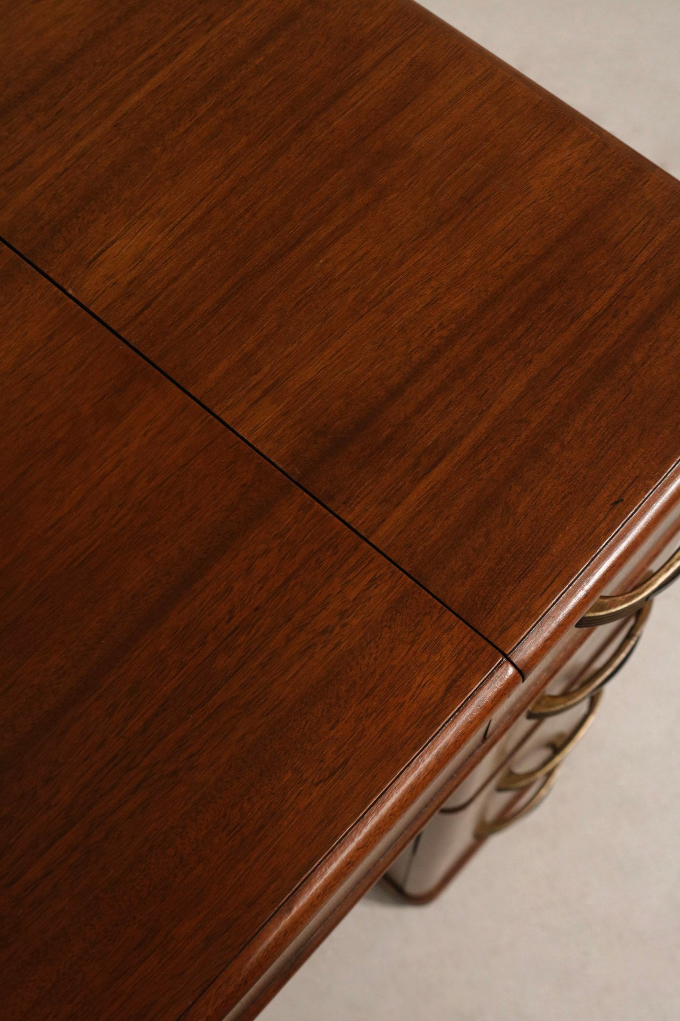 Detail: back view of vintage walnut wood desk side table showing panel construction, aged patina and solid wood frame