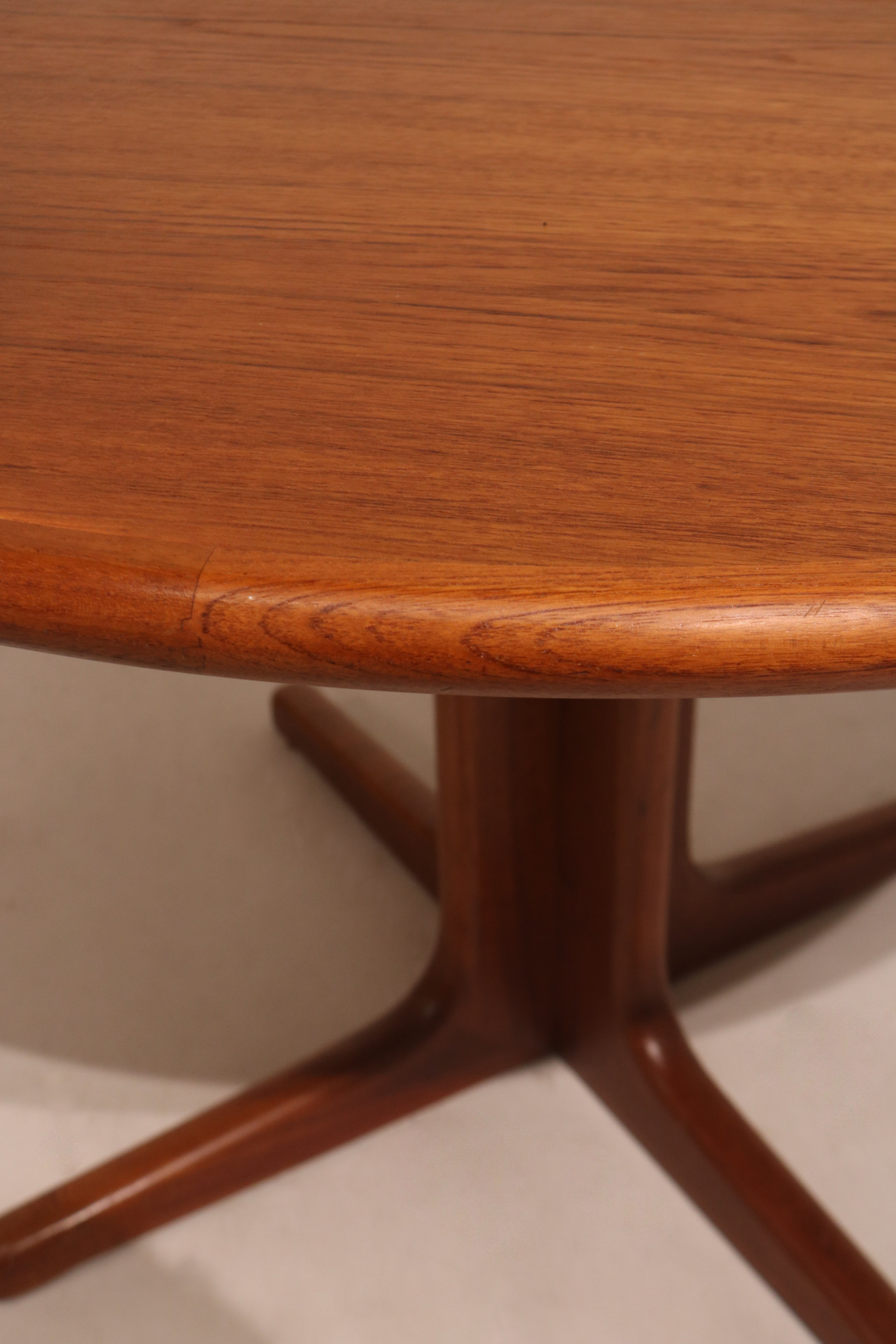 Detail of table edge showing smooth rounded edges and solid teak wood construction