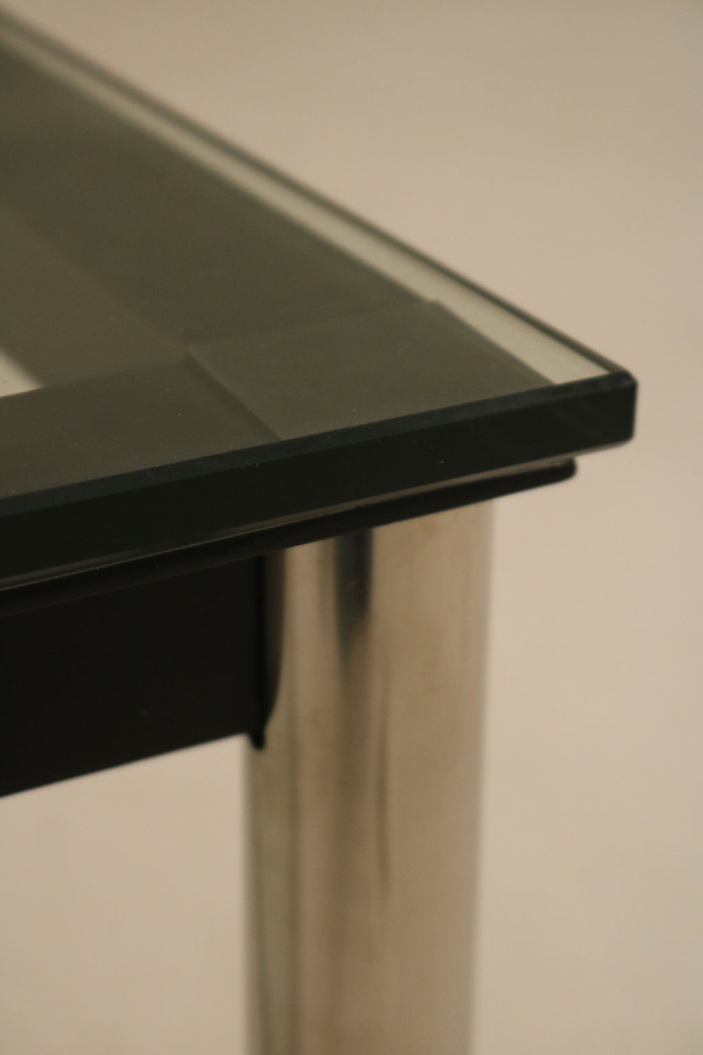 Side angle showing corner connection between glass top and steel frame on Mcm coffee table