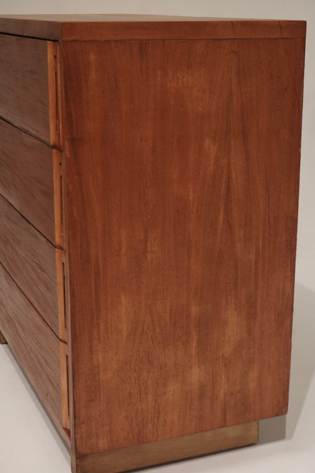 Detail of drawer fronts on solid wood dresser chest, stained walnut finish with visible grain and consistent sanded surface texture