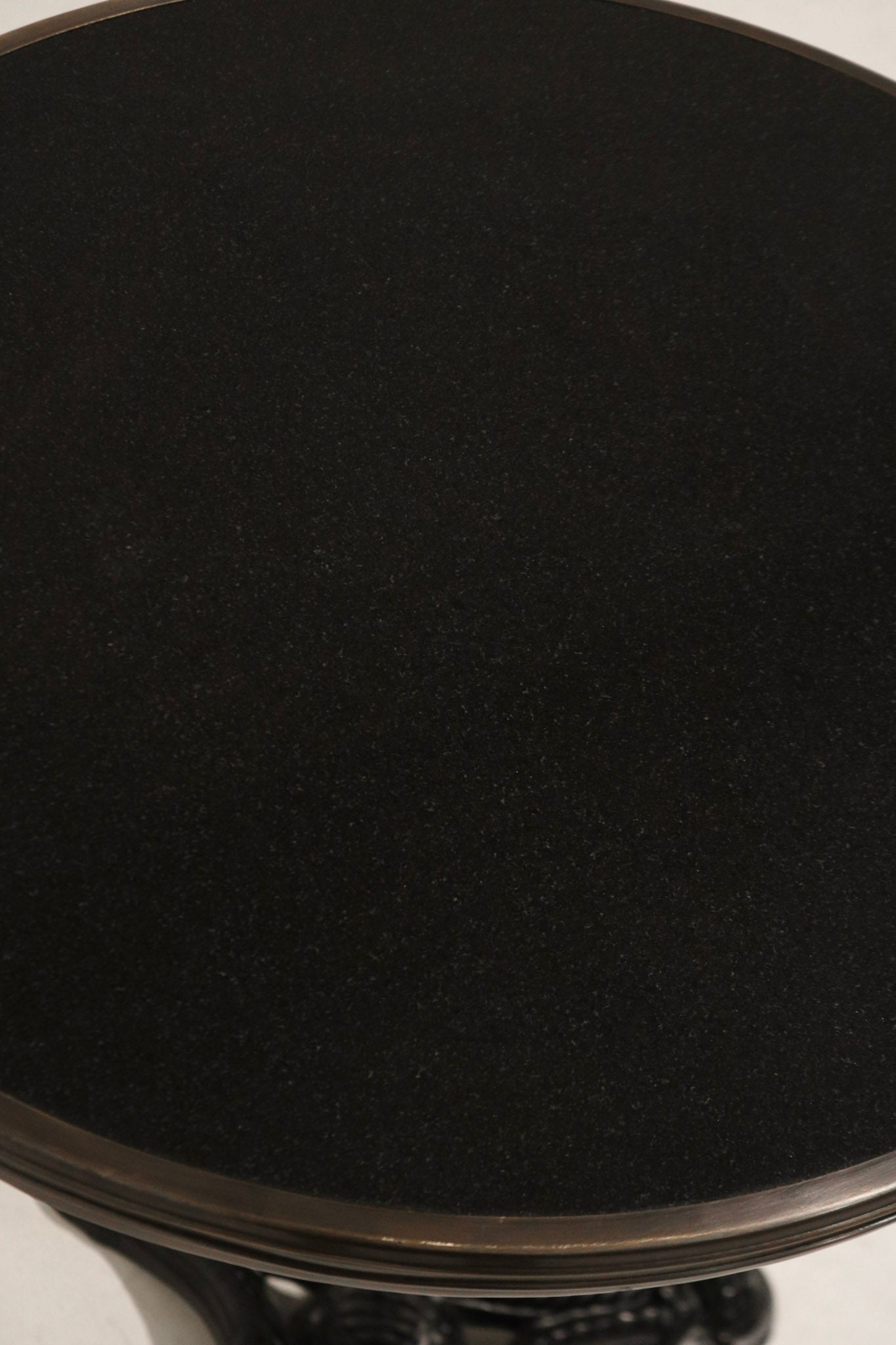 Zoomed-in image of vintage iron base foot detailing with patina finish on Bistro Table