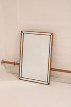 Detail view of mirror wood frame finish, showcasing gold color and fine grain texture