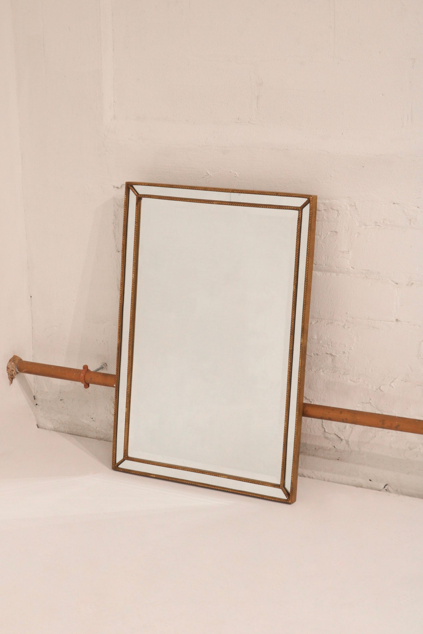 Detail view of mirror wood frame finish, showcasing gold color and fine grain texture