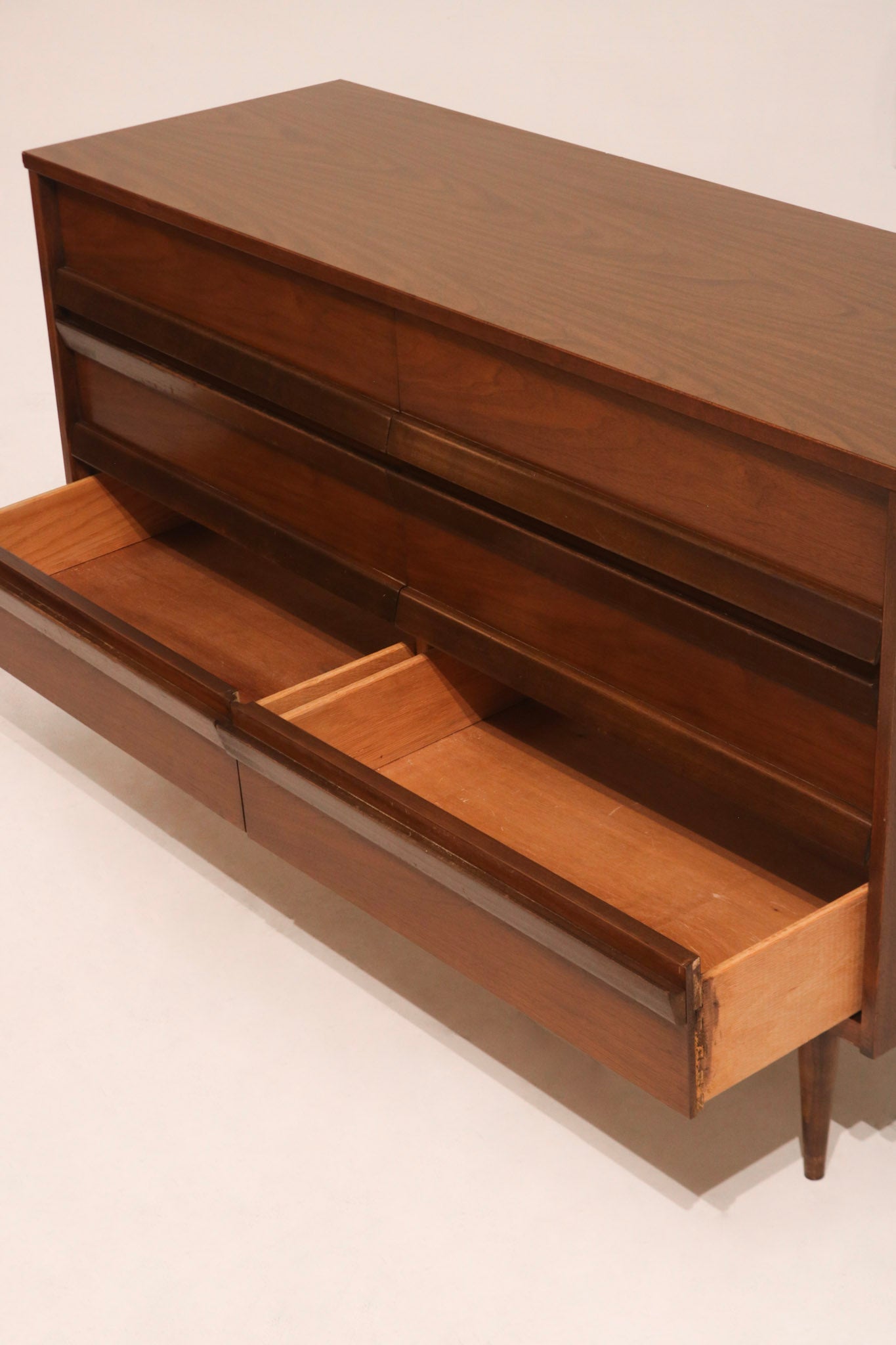 Base leg design of the Mcm Bassett dresser, showing solid wood legs and structure