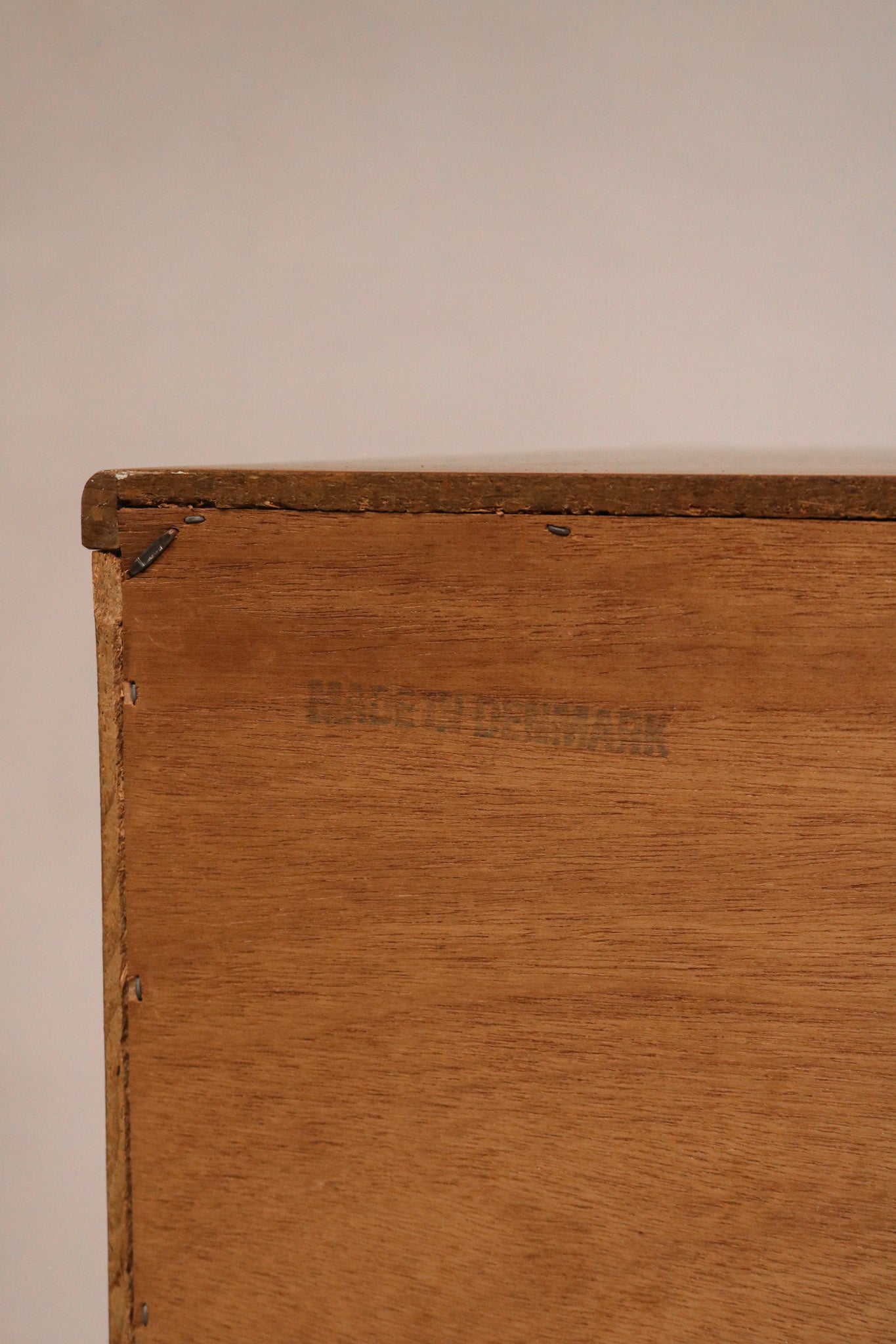 Close-up of teak wood grain texture on drawer fronts of vintage Danish MCM dresser