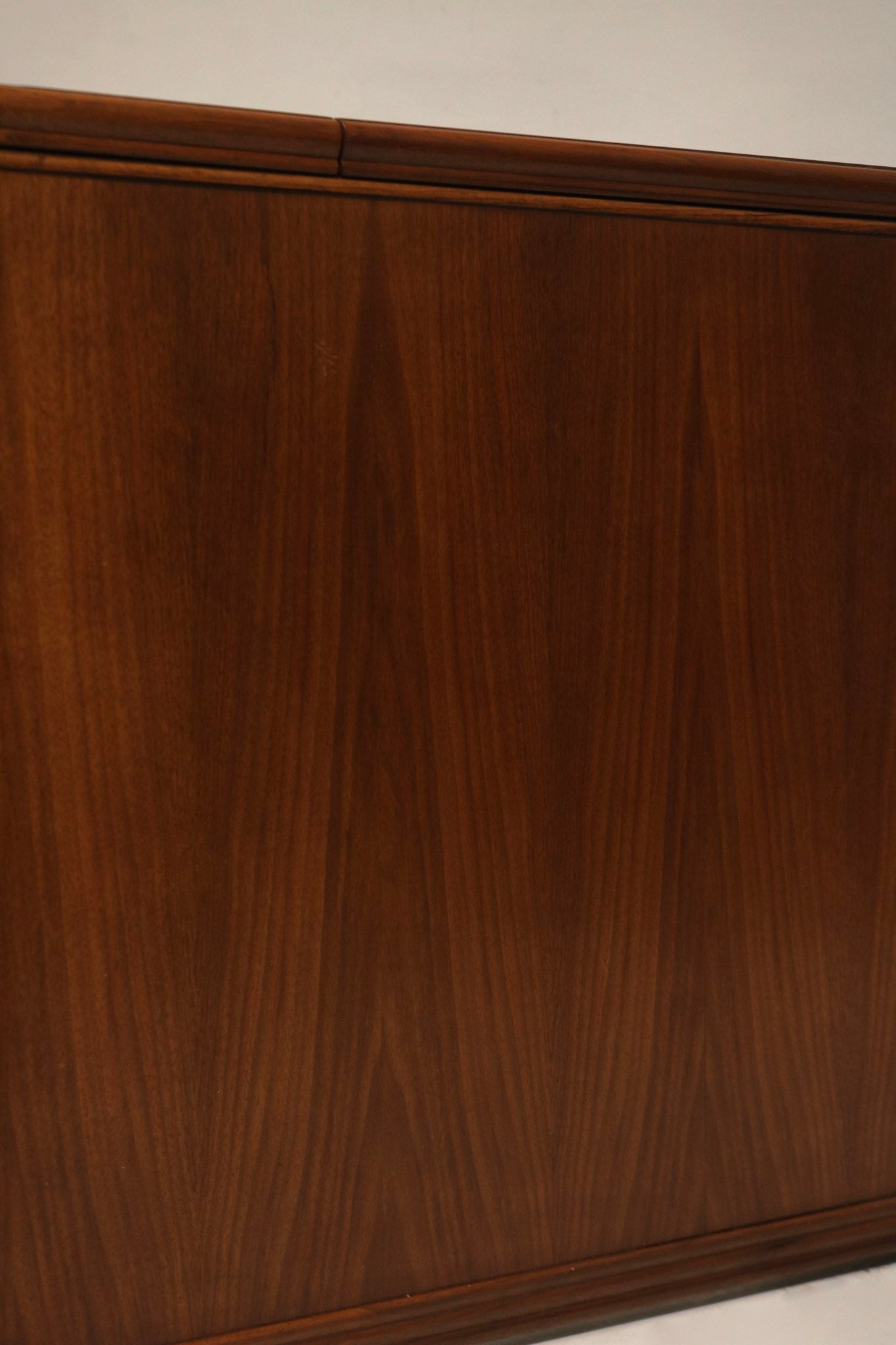 Detail: walnut wood tabletop close-up showing light scratch on top, vintage finish, visible wood grain and surface patina