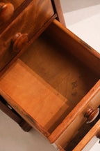 Detail of wooden drawer front with original vintage metal pull hardware and light stain