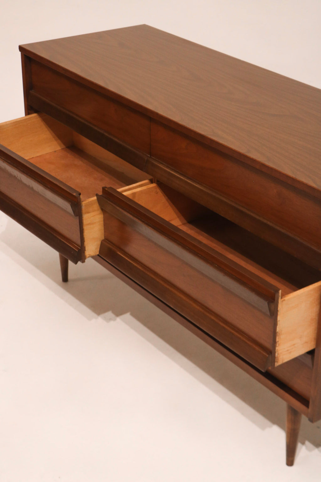 Drawer partially opened to show internal storage space and veneer continuity