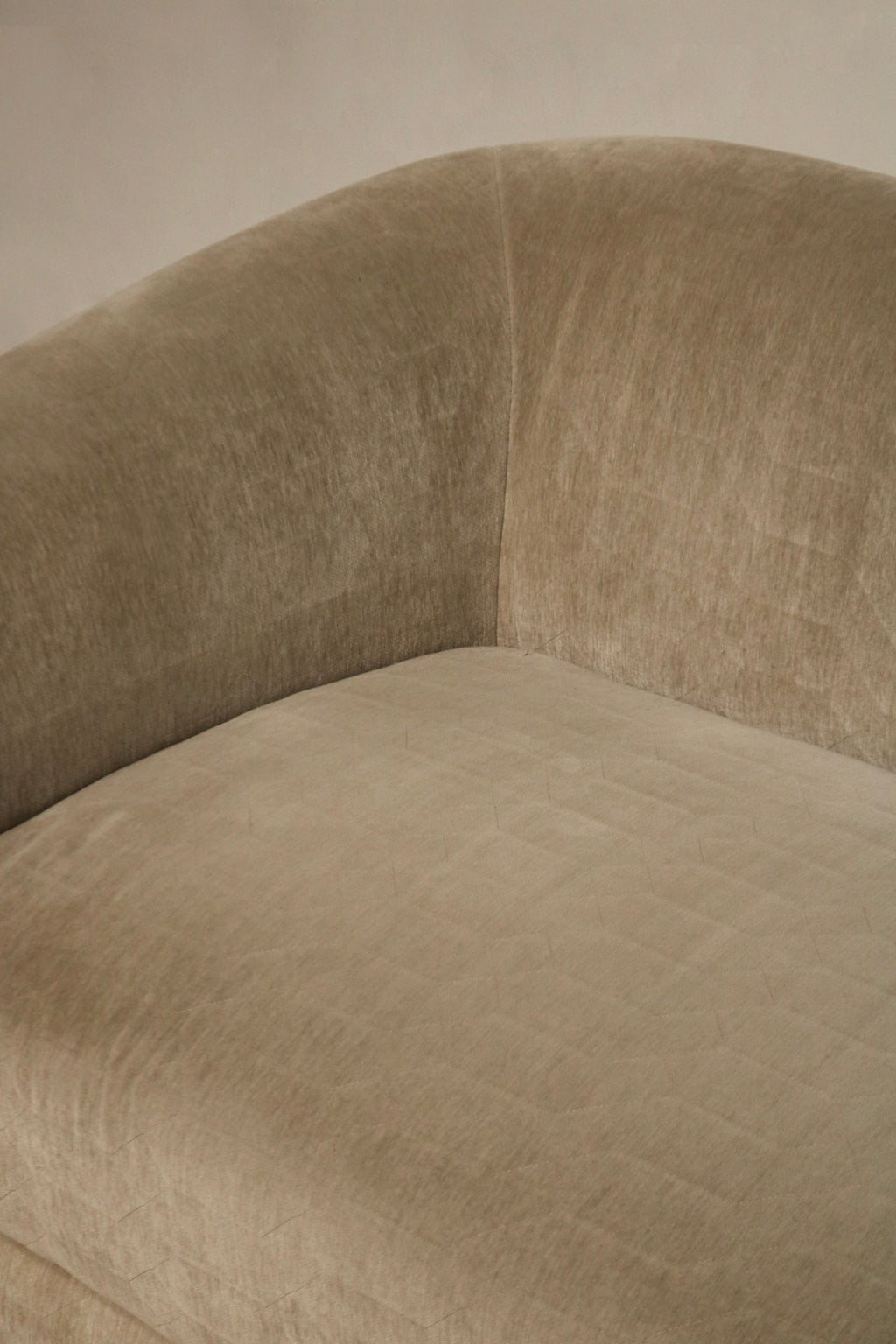 Detail of cushion edge and seam stitching on champagne velvet fabric, tailored seams and reinforced construction with slight wear at corner