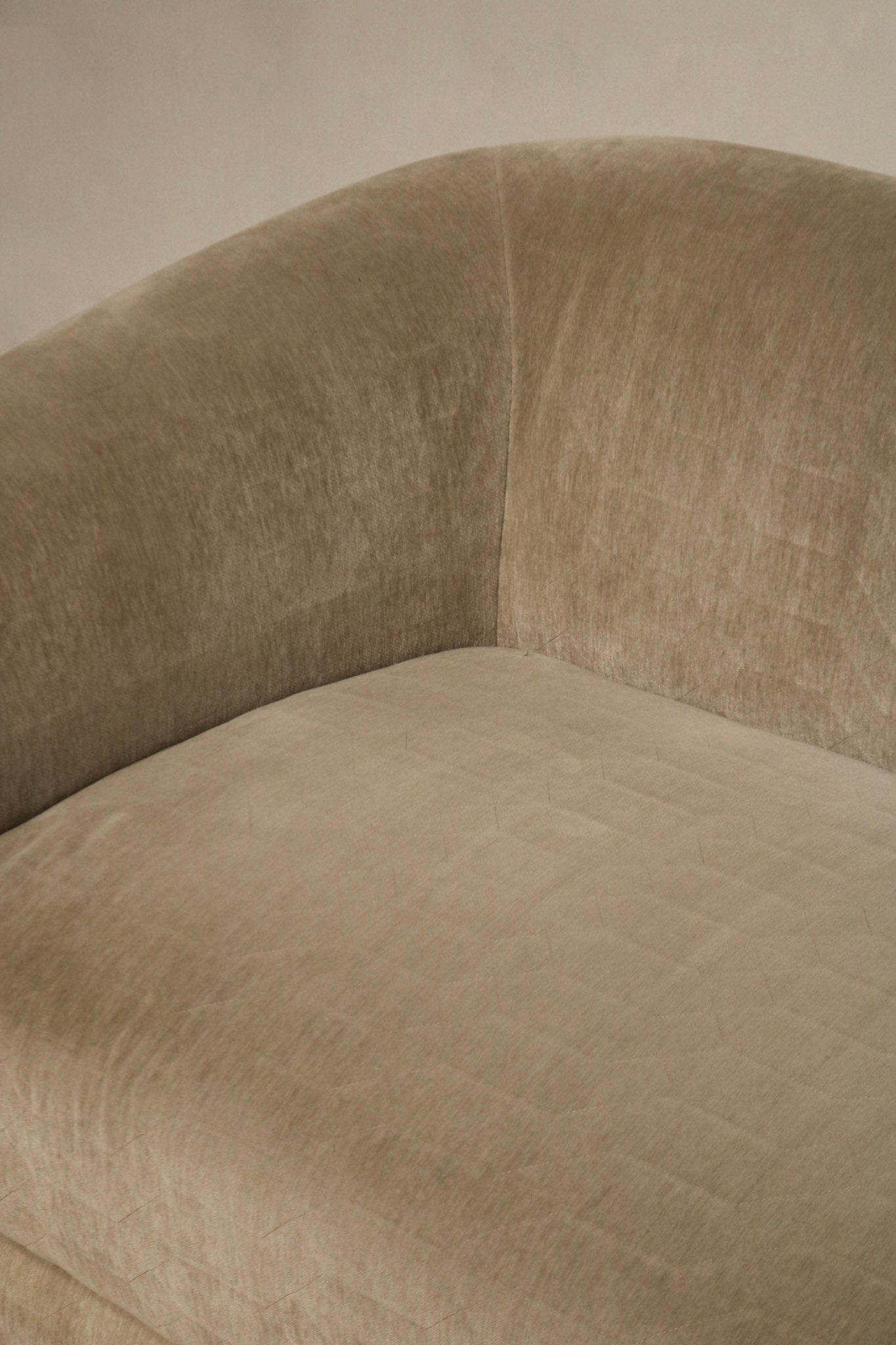 Detail of cushion edge and seam stitching on champagne velvet fabric, tailored seams and reinforced construction with slight wear at corner