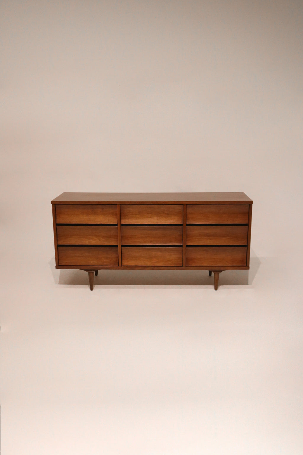 Full view of Mid Century Modern walnut wood dresser with 9 drawers by Johnson Carper in vintage NYC style