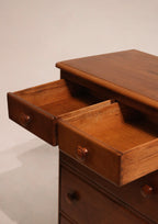 Low angle view capturing highboy’s tall structure and warm wood finish