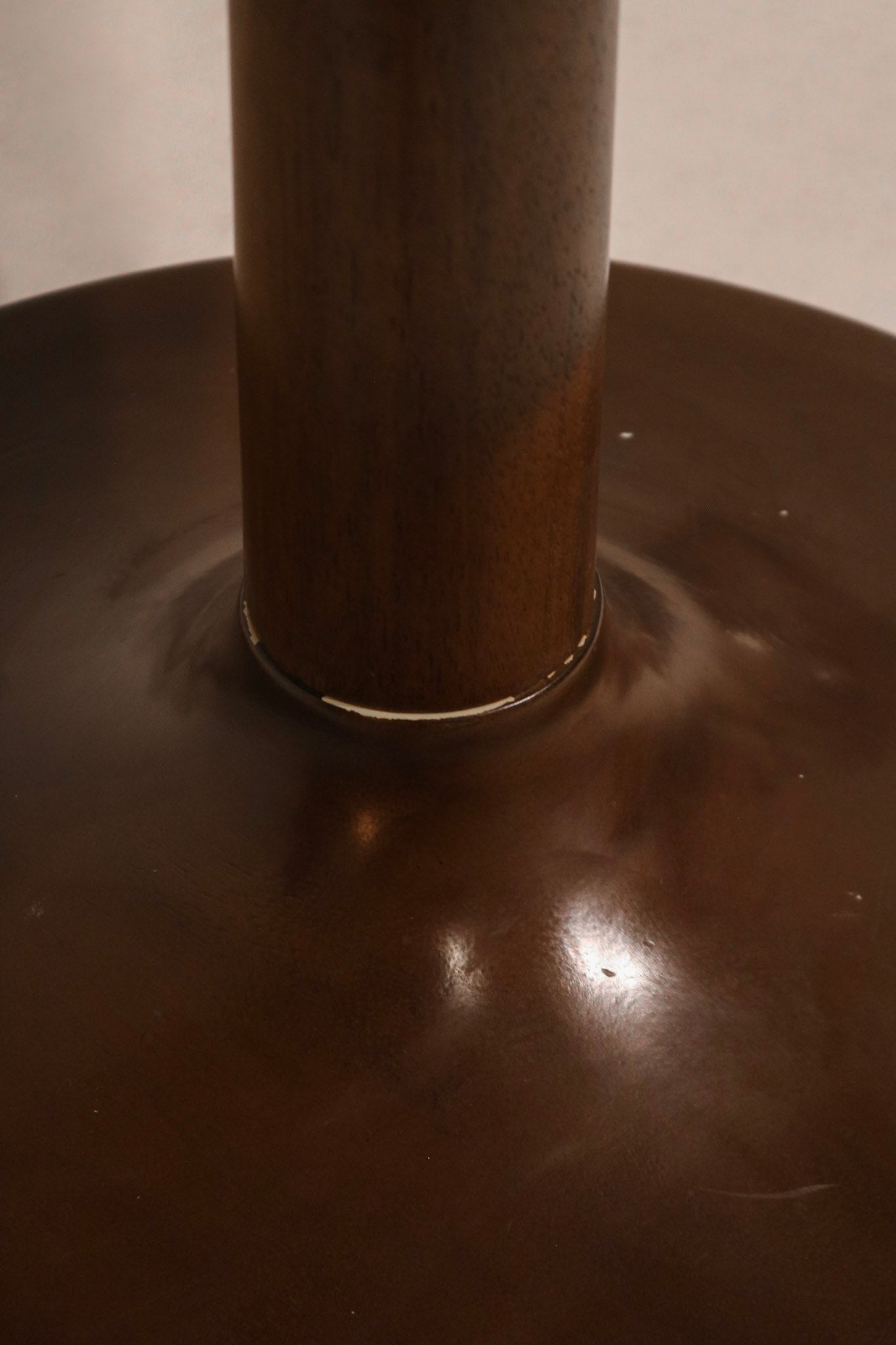 Angle view of dining table showing glossy wood texture and stylish round design