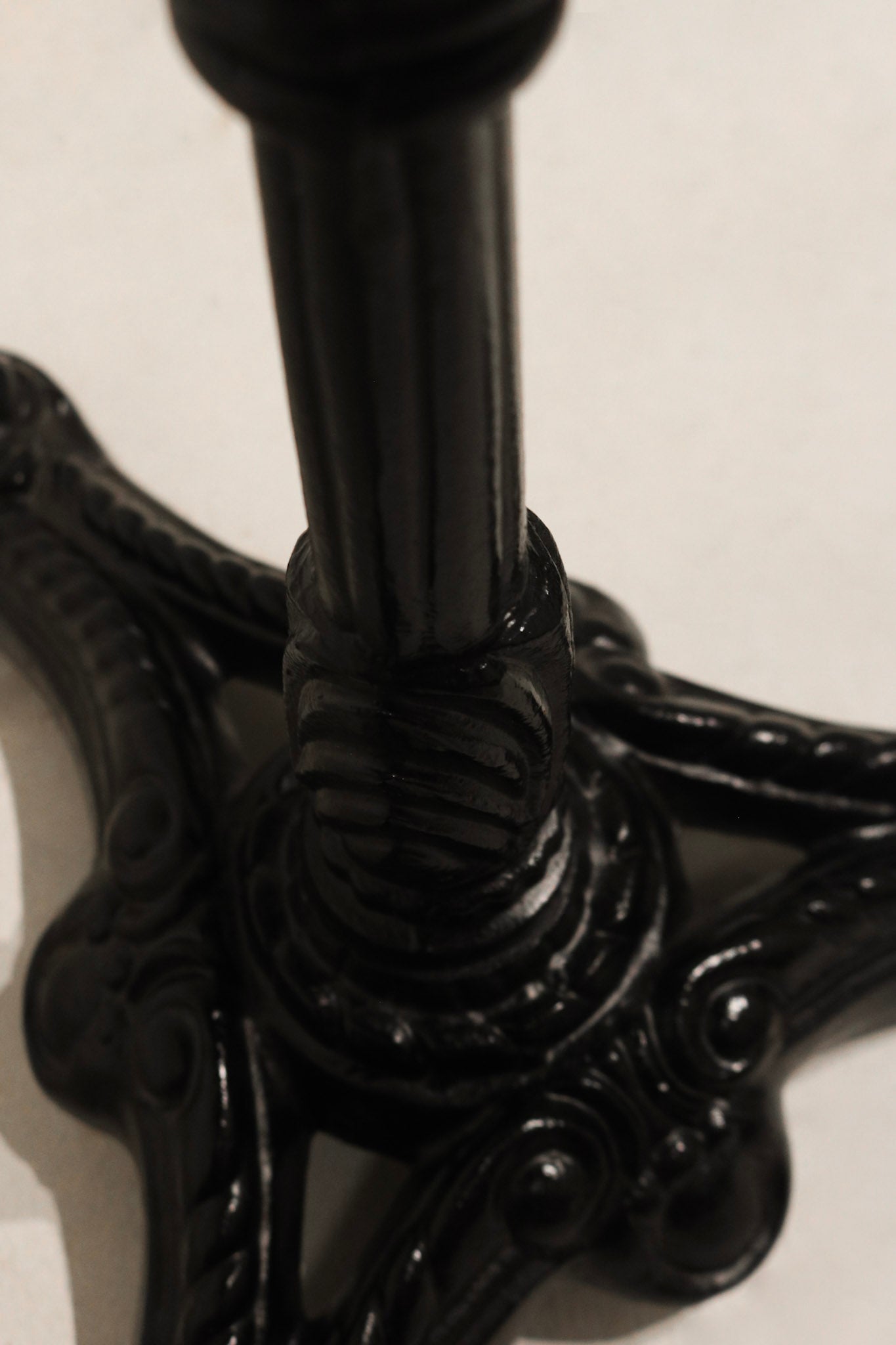 Side angle of Vintage Stone Iron Metal Round Bistro Table showing curved metalwork and rustic finish