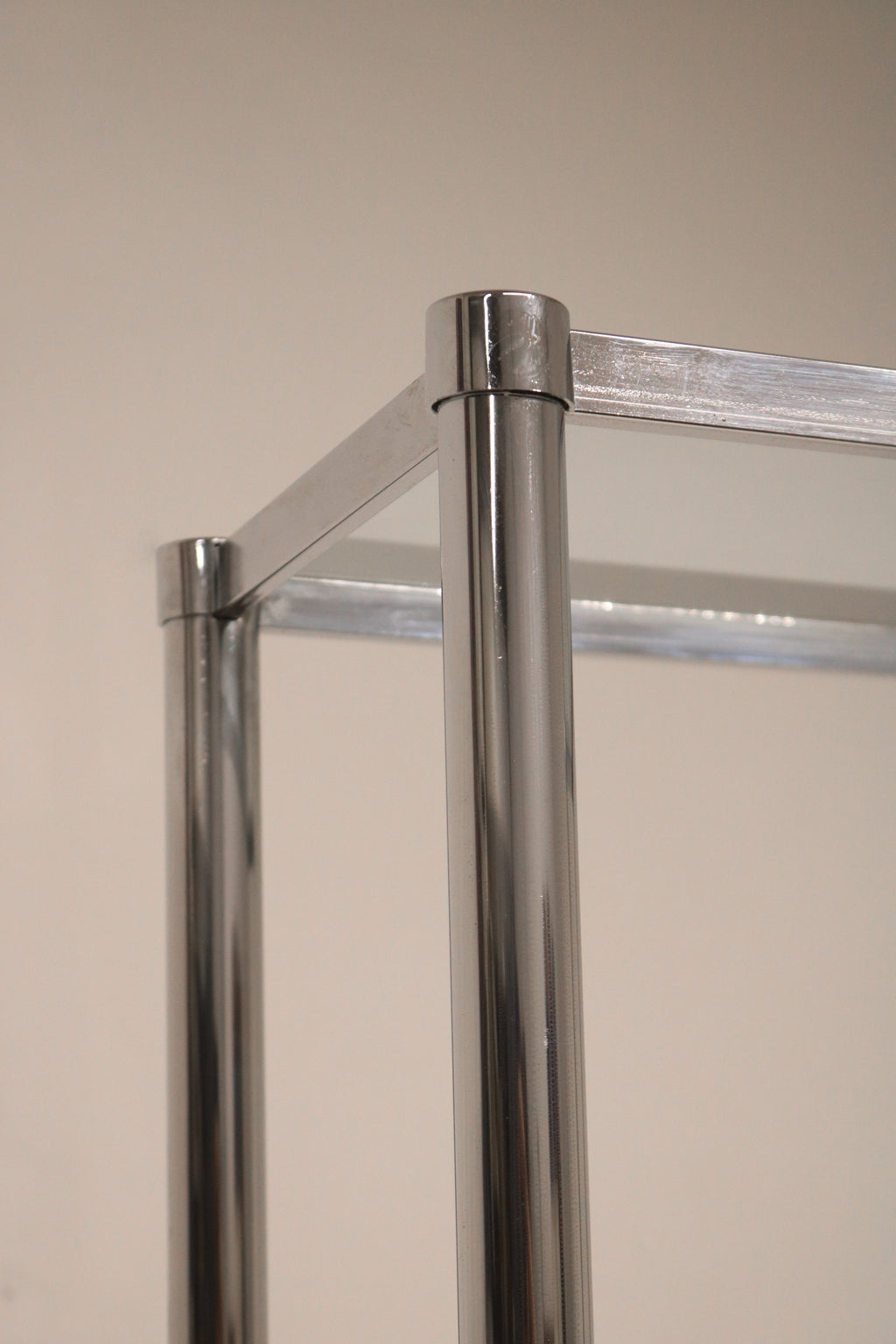 Detailed view of chrome steel frame and glass construction on Vintage Mcm Bookcase