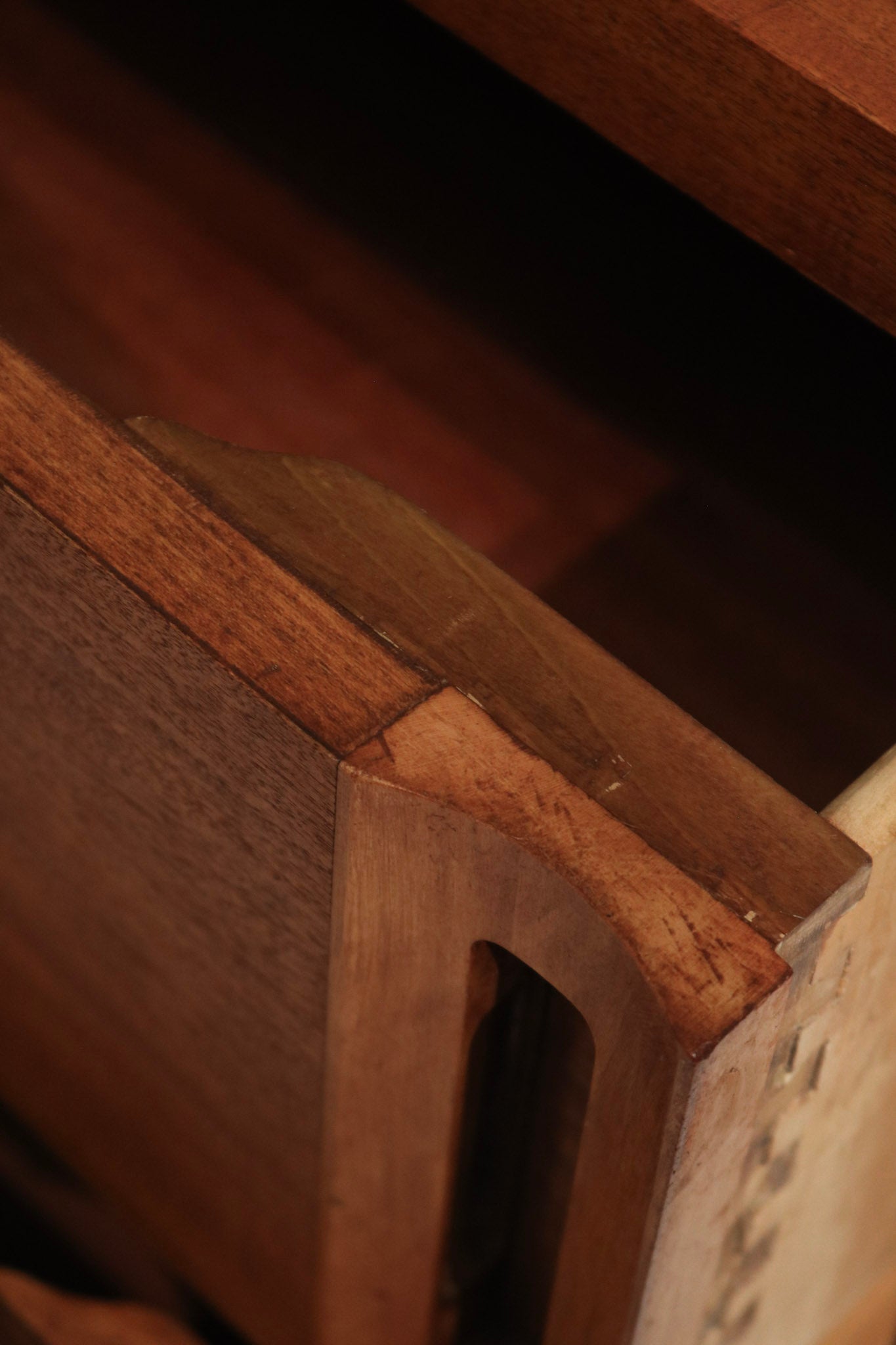Detail image of finish variations and touch marks on stained walnut solid wood dresser, authentic vintage patina and sanded surface