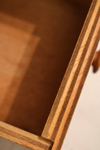 Angled side view of slim vertical oak storage cabinet with smooth finish