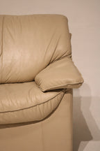 Close-up of backrest cushions on beige leather vintage couch, plush and well-shaped