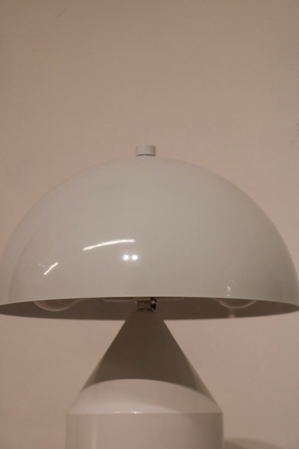 Bottom view of lamp base structure in white coated metal with protective pads