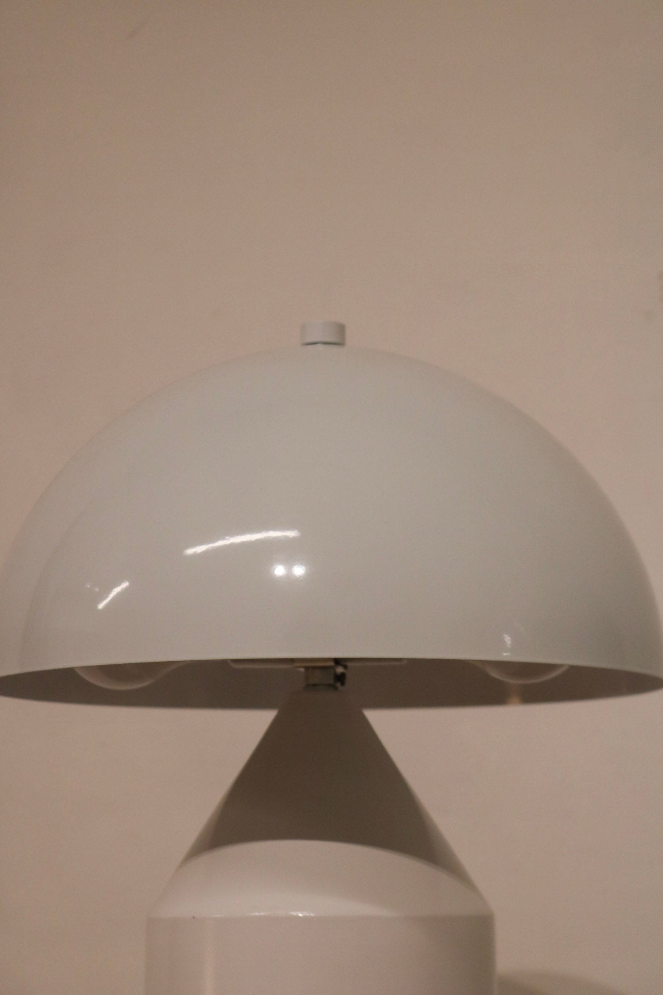 Bottom view of lamp base structure in white coated metal with protective pads