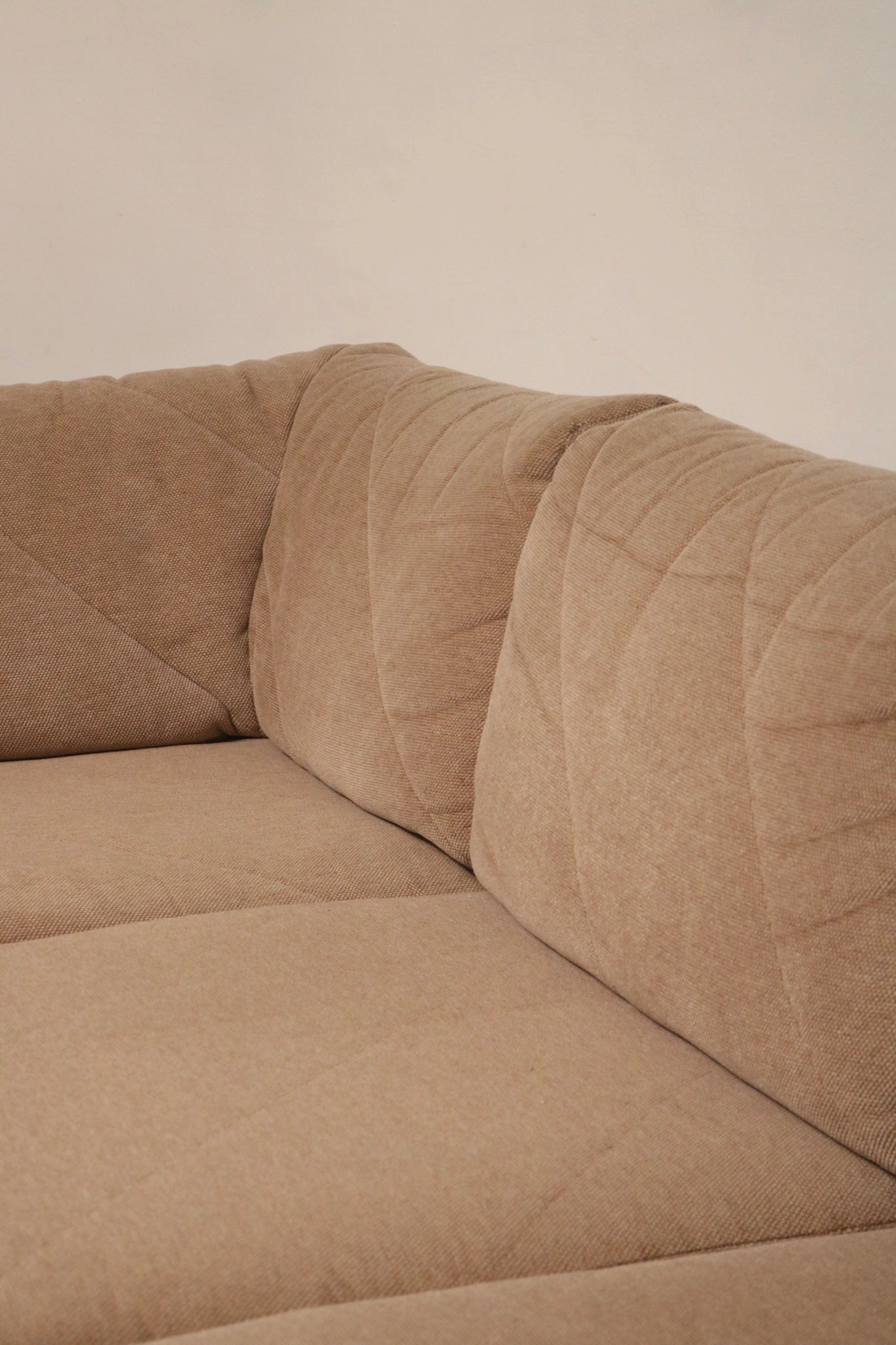 Corner connection detail showing modular frame joint and fabric-wrapped frame of Mcm sectional sofa, demonstrating solid vintage construction